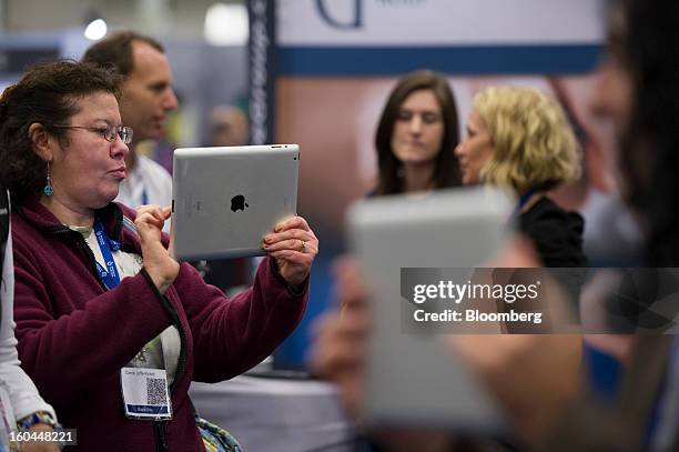 Attendees take photographs and record videos using Apple Inc. IPads at the Macworld/iWorld conference at the Moscone Center West in San Francisco,...