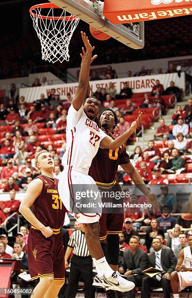 Guard Royce Woolridge of the Washington State Cougars attempts to shoot a goal while Carrick Felix and Jonathan Gilling of the Arizona State Sun...