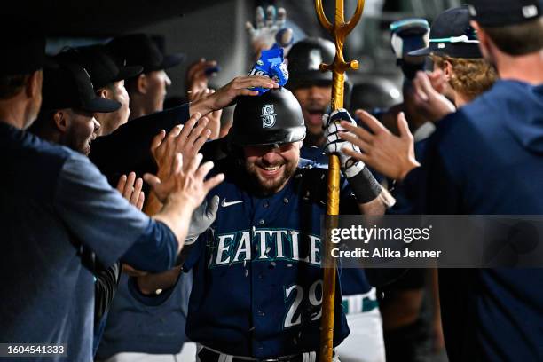 Cal Raleigh of the Seattle Mariners celebrates with teammates after hitting a two-run home run during the eighth inning against the San Diego Padres...