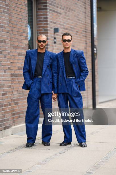 Guest wears black sunglasses, a black t-shirt, a royal navy blue striped print pattern blazer jacket, matching royal navy blue striped print pattern...