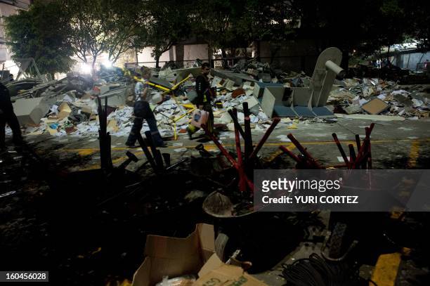 Rescue workers search for victims at the headquarters of state-owned Mexican oil giant Pemex in Mexico City on January 31 following a blast inside...