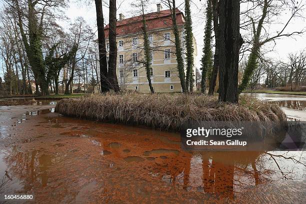 Iron-rich sludge lies on top of thawing ice in the ponds that are fed by a nearby creek next to Schloss Vetschau palace on January 31, 2013 in...