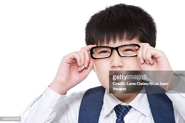 nearsighted schoolboy having trouble seeing things clearly adjusting his glasses - entrecerrar los ojos fotografías e imágenes de stock