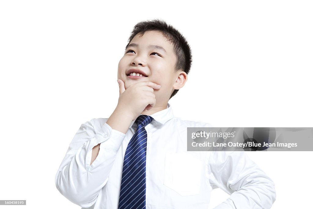 Lovely schoolboy thinking with hand on chin