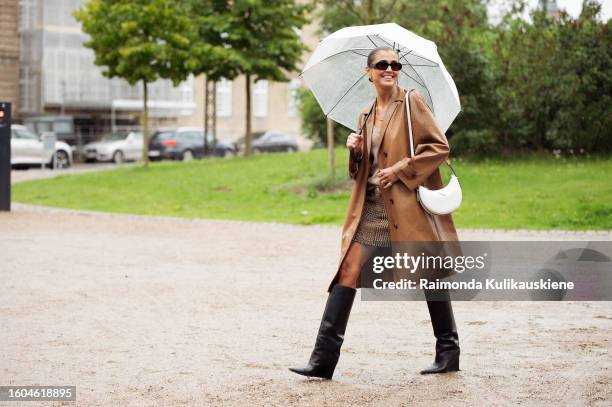 Darja Barannik wears a brown leather coat, and a white Prada bag wears outside OpéraSport during the Copenhagen Fashion Week Spring/Summer 2024 on...