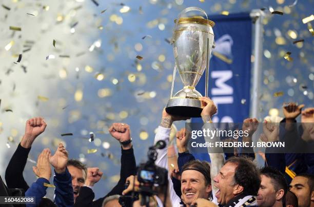 David Beckham of the LA Galaxy holds aloft the winning trophy following victory over the Houston Dynamo in their MLS Cup final at the Home Depot...