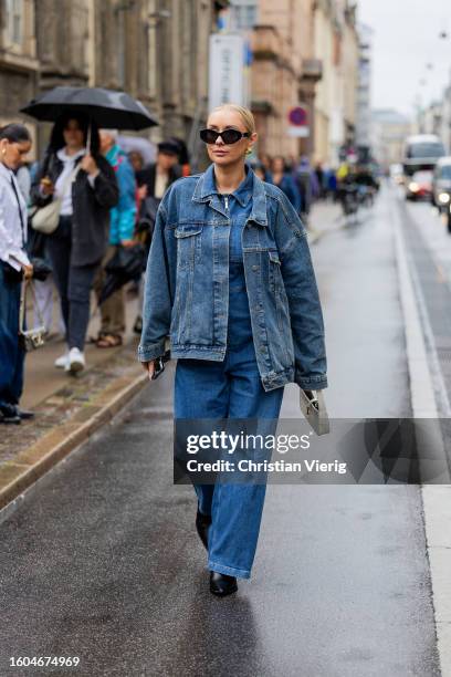 Justyna Czerniak wears denim jacket, jeans, bag, sunglasses outside Marimekko during the Copenhagen Fashion Week Spring/Summer 2024 on August 09,...