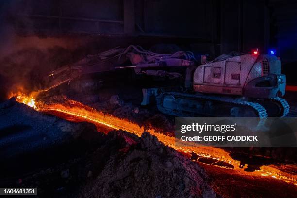 Molten iron flows from the bottom of Blast Furnace number four at the Tata Steel Port Talbot integrated iron and steel works in south Wales on 15...