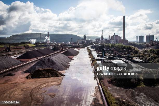 Raw materials to make iron sit in heaps at the Tata Steel Port Talbot integrated iron and steel works in south Wales on 15 August, 2023. Port...