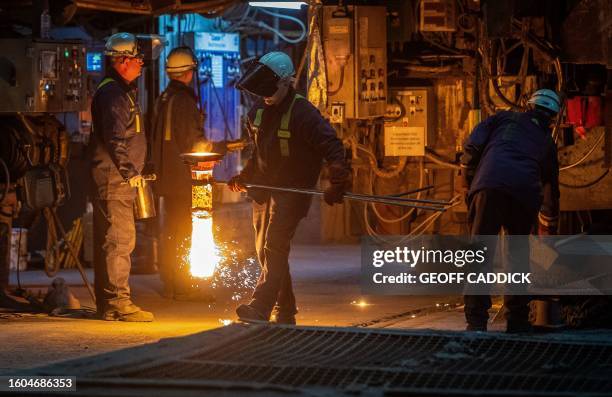 Steel worker carries a refraction tube, which is used to allow molten steel to flow down from a tun dish into the steel mould at the Tata Steel Port...