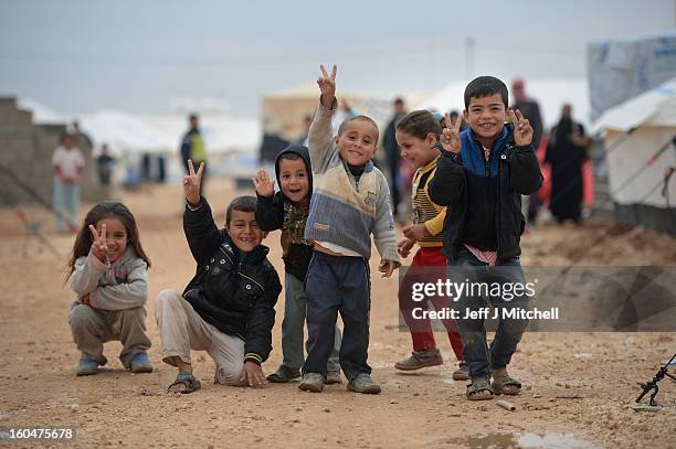 Children pose for a picture as Syrian refugees go about their daily business in the Za'atari refugee camp on February 1, 2013 in Za'atari, Jordan....