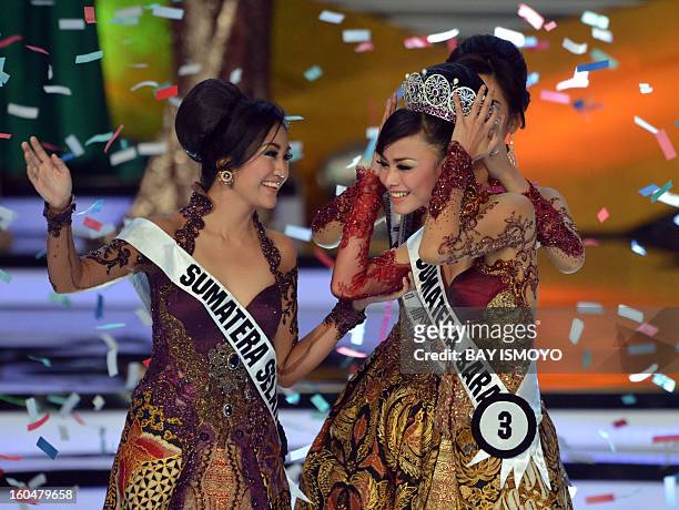 Putri Indonesia 2012-2013 Whulandary is crowned by Putri 2011 Maria Selena during the grand final in Jakarta on February 2, 2013 as her competitor...