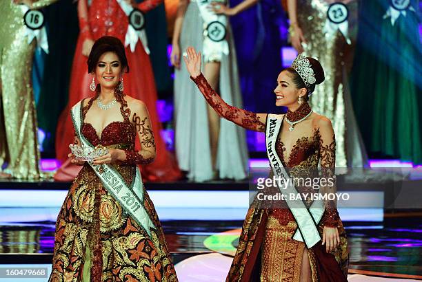 Newly-crowned Miss Universe 2012 Olivia Culpo of the US gestures as Miss Indonesia 2011 Maria Selena carries the crown for the 2012-2013 winner...