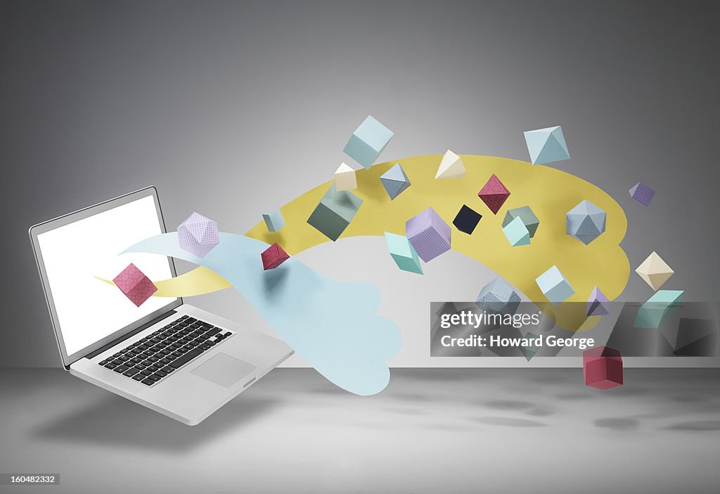 Laptop with geometric shapes floating from screen