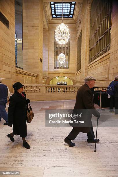 People walk in Grand Central Terminal beneath chandeliers during centennial celebrations on the day the famed Manhattan transit hub turns 100 years...