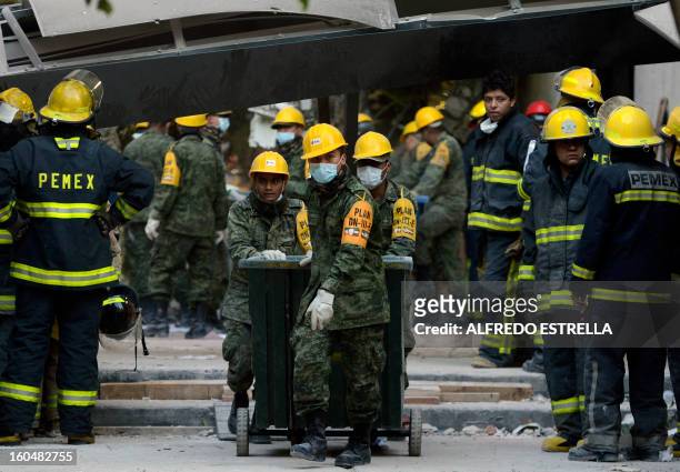 Mexican soldiers and Pemex workers stand inside the premises of the building that houses state-owned Mexican oil giant Pemex following a blast on the...
