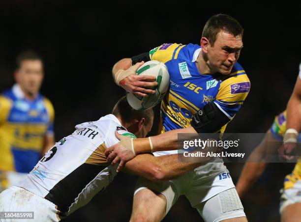 Kevin Sinfield of Leeds Rhinos is tackled by Daniel Holdsworth of Hull FC during the Stobart Super League match between Leeds Rhinos and Hull FC at...