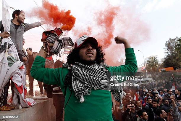 An Egyptian protester holds a smoke flare during anti-government protests outside the Egyptian Presidential Palace in the suburb of Heliopolis on...