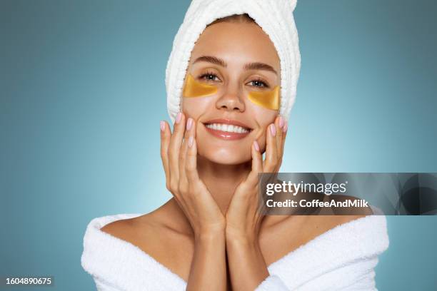 woman with eye patches having face massage - medical eye patch stockfoto's en -beelden