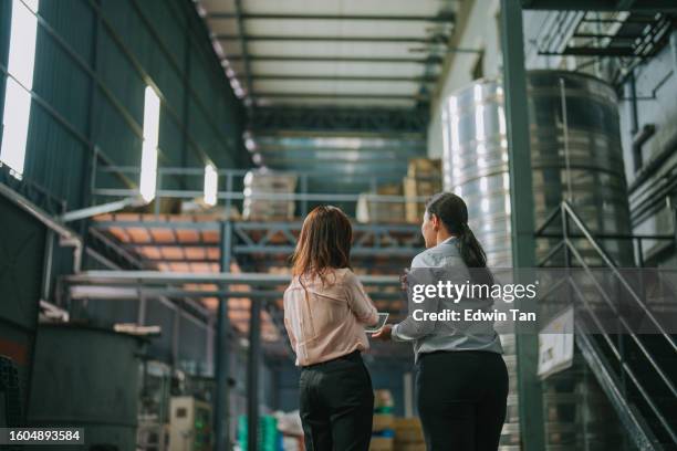 2 asian chinese female factory management and foreperson discussion in warehouse on goods delivery logistic and production schedule - visit stock pictures, royalty-free photos & images