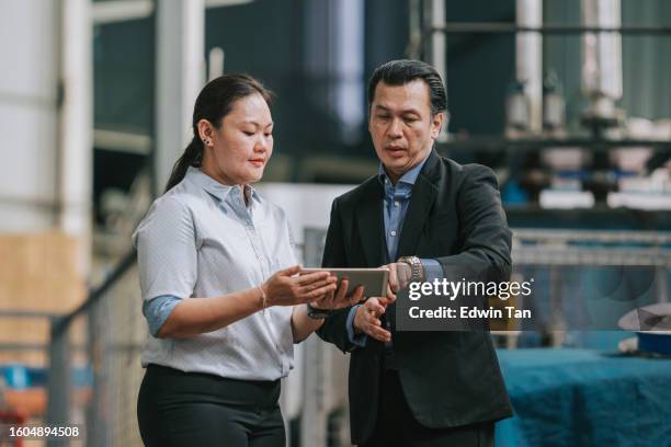 asian factory businessman checking factory warehouse delivery schedule with foreperson using digital tablet - east asian ethnicity stock pictures, royalty-free photos & images