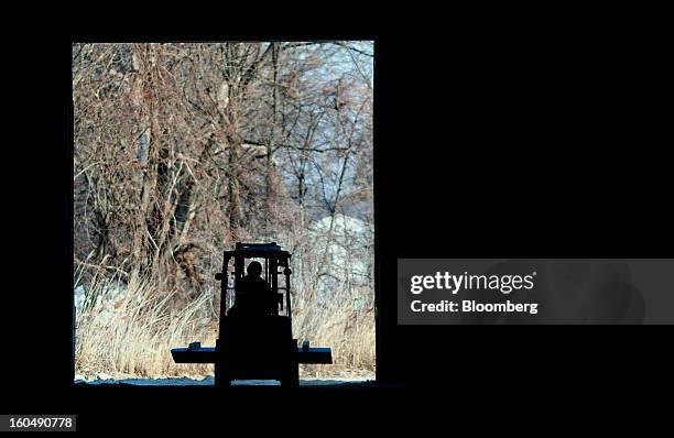 The silhouette of a worker using a forklift to move a slab of sandstone is seen at the Cleveland Quarries facility in Vermilion, Ohio, U.S., on...