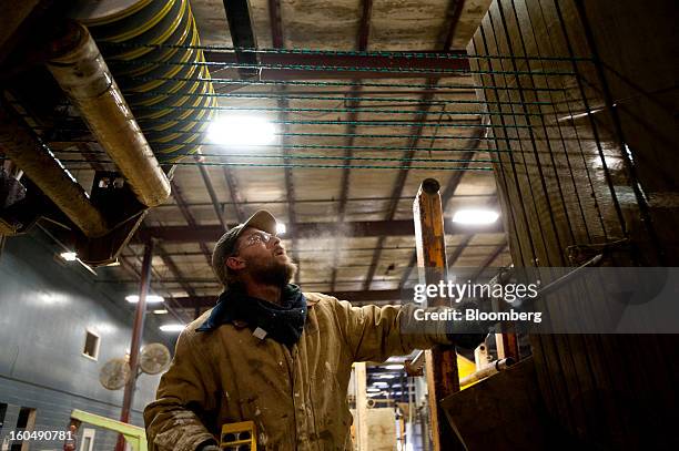 Worker pries apart multiple cuts in a block of sandstone to free the tension on a wire saw at the Cleveland Quarries facility in Vermilion, Ohio,...