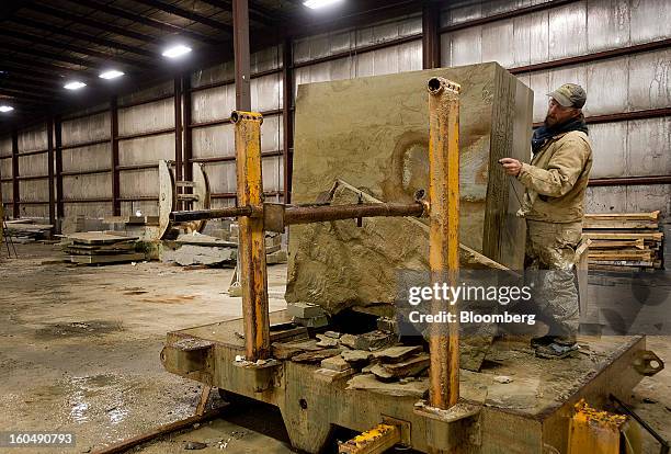 Worker writes measurements for multiple cuts in a block of sandstone at the Cleveland Quarries facility in Vermilion, Ohio, U.S., on Friday, Feb. 1,...