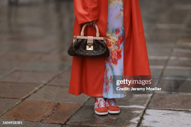 Karin Teigl seen wearing Jean Paul Gaultier light blue colorful print pattern long dress, NA-KD dark orange leather long coat, Louis Vuitton brown...