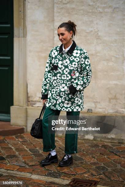 Guest wears white squared sunglasses, gold earrings, a white shirt, a dark green with white flower print pattern jacket from Carhartt x Marni, dark...