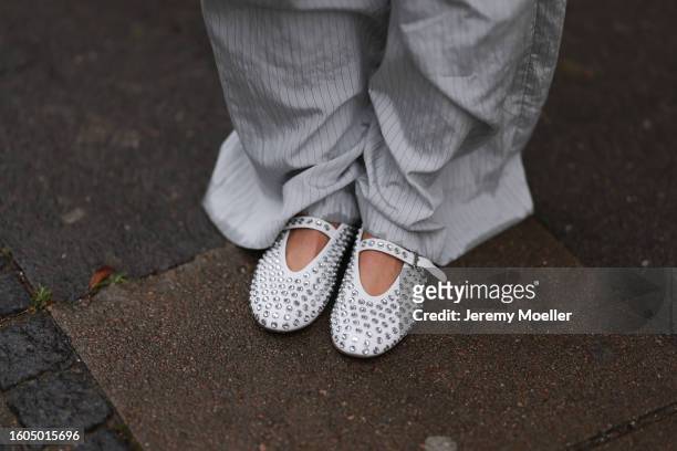 Karin Teigl seen wearing Zara grey striped nylon wide leg pants, Alaia white leather sparkling / rhinestones studded ballerinas, during the...