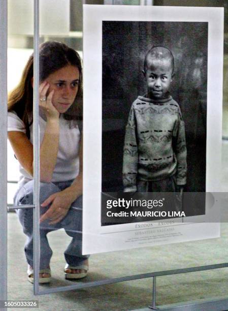 Woman contemplates a photograph in the "Exodus" exhibition of photographs by Brazilian Sebastiao Salgado at the Industrial Federation Cultural Center...