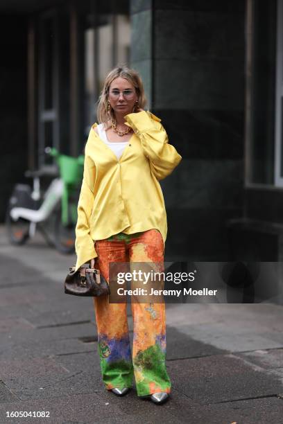 Karin Teigl seen wearing Andy Wolf light blue transparent pilot sunglasses, gold pendant earrings, Louis Vuitton gold statement chain necklace, white...