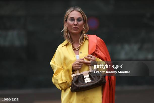 Karin Teigl seen wearing Andy Wolf light blue transparent pilot sunglasses, gold pendant earrings, Louis Vuitton gold statement chain necklace, white...