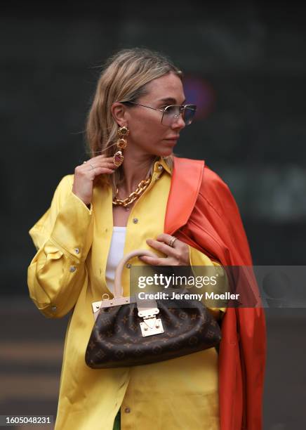 Karin Teigl seen wearing Andy Wolf light blue transparent pilot sunglasses, gold pendant earrings, Louis Vuitton gold statement chain necklace, white...