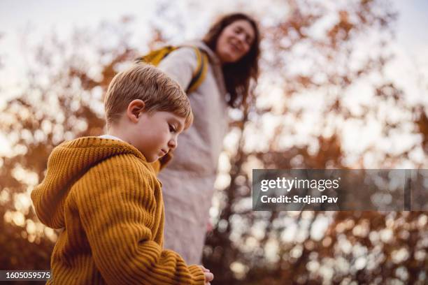 sad little boy walking in nature with his mom - asperger syndrome stock pictures, royalty-free photos & images