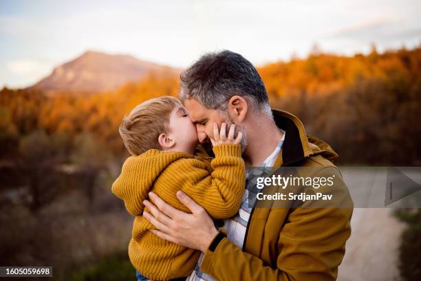 padre e hijo disfrutando de un día de otoño sin preocupaciones en la naturaleza - padre e hijo fotografías e imágenes de stock