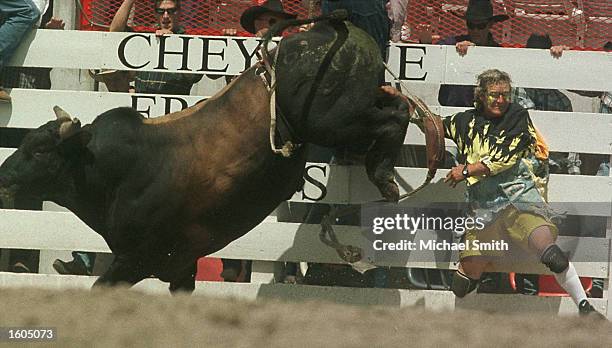 Bullfighter and Rodeo clown Rick Chatman has a close call with a bull during competition at the Cheyenne Frontier Days Rodeo July 27, 2001 in...