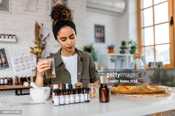 une femme teste une nouvelle note de parfum dans son magasin d’atelier de cosmétiques - parfumeur photos et images de collection