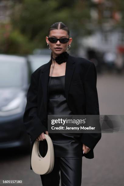 Sophia Geiss seen wearing black sunglasses, black strap rose choker necklace, silver earrings, black oversized blazer jacket, black leather long top,...
