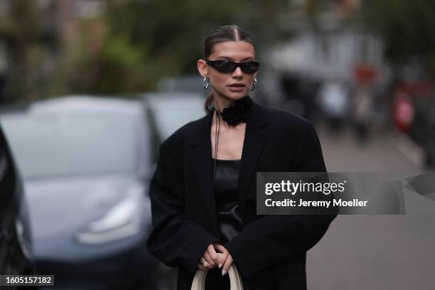 Sophia Geiss seen wearing black sunglasses, black strap rose choker necklace, silver earrings, black oversized blazer jacket, black leather long top,...