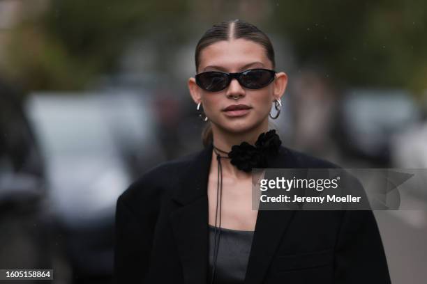 Sophia Geiss seen wearing black sunglasses, black strap rose choker necklace, silver earrings, black oversized blazer jacket, black leather long top,...