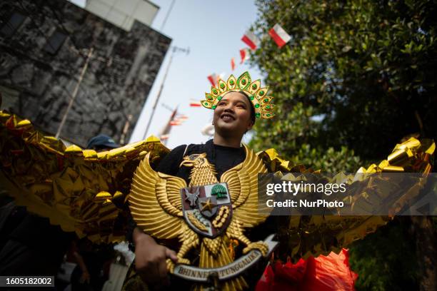 Indonesian youth holds the national emblem of Indonesia is called Garuda Pancasila from recycled materials during a carnival with Environmental Issue...
