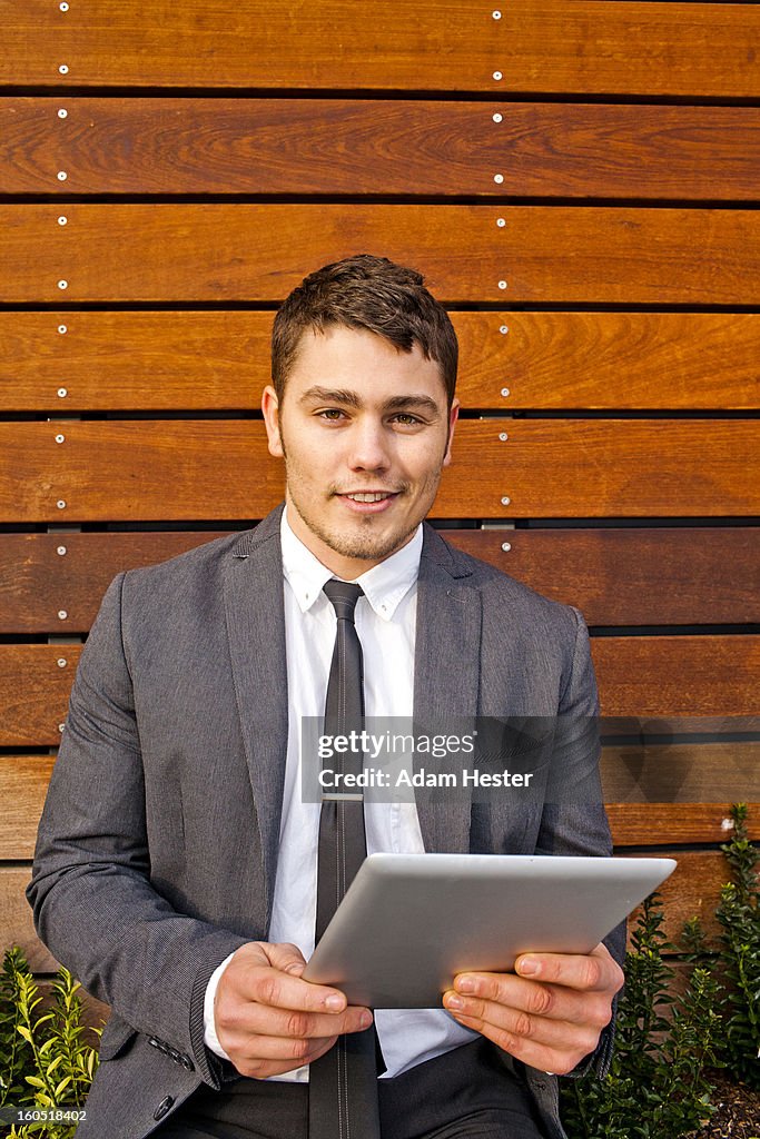 A young businessman using a tablet device downtown