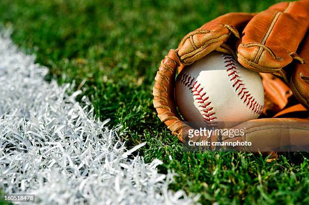 new baseball in glove along foul line - baseball stock pictures, royalty-free photos & images