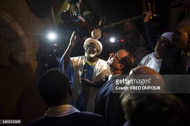 France's President Francois Hollande flanked by Mali's interim president Dioncounda Traore , visit the Djingareyber mosque in Timbuktu, the second...