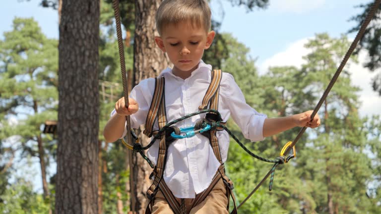 Wiking Over Rope Portrait of little boy walking over rope strung between trees in scout ...