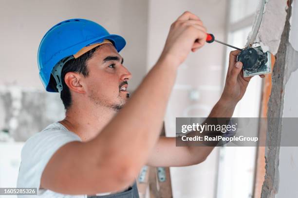 young worker wearing safety helmet renovating apartment - broken light bulb stock pictures, royalty-free photos & images