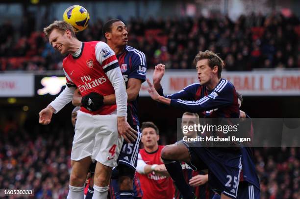Per Mertesacker of Arsenal competes for the ball against Steven N'Zonzi and Peter Crouch of Stoke City during the Barclays Premier League match...