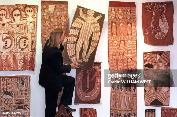 Sotheby's Aboriginal art specialist Tim Klingender makes a final adjustment to a bark painting by Mick Mundaingu which is part of a exhibition...